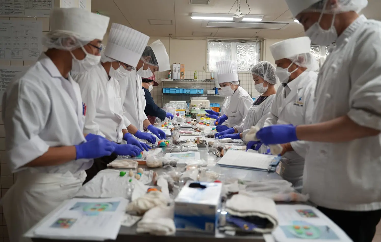 和菓子職人が美しい青と白の練り切りを仕上げている様子。クリックするとYouTube動画が再生されます。